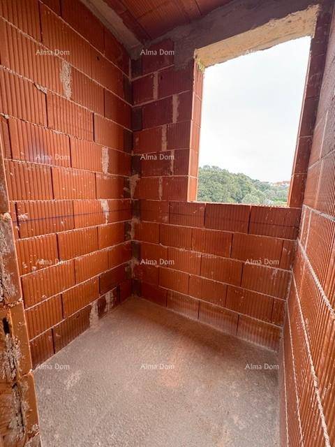 Kleiner Rohbau-Raum mit Ziegelwänden und einer Fensteröffnung mit Blick auf Bäume.