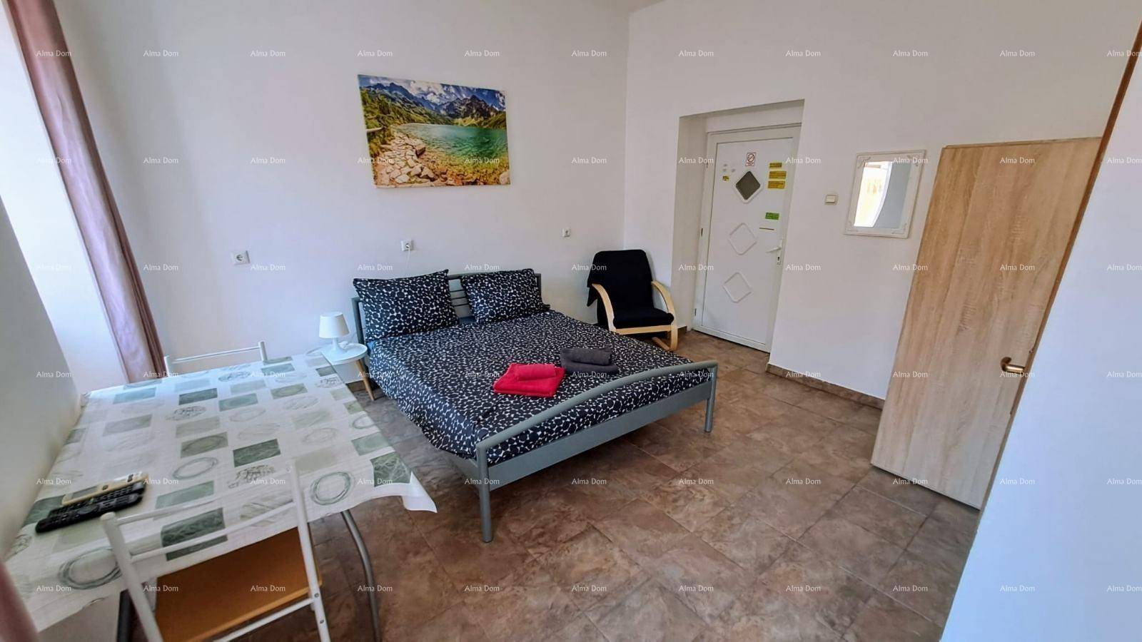 Studio-Apartment mit Schlafbereich, Esstisch und Kunst an der Wand, funktional und hell.