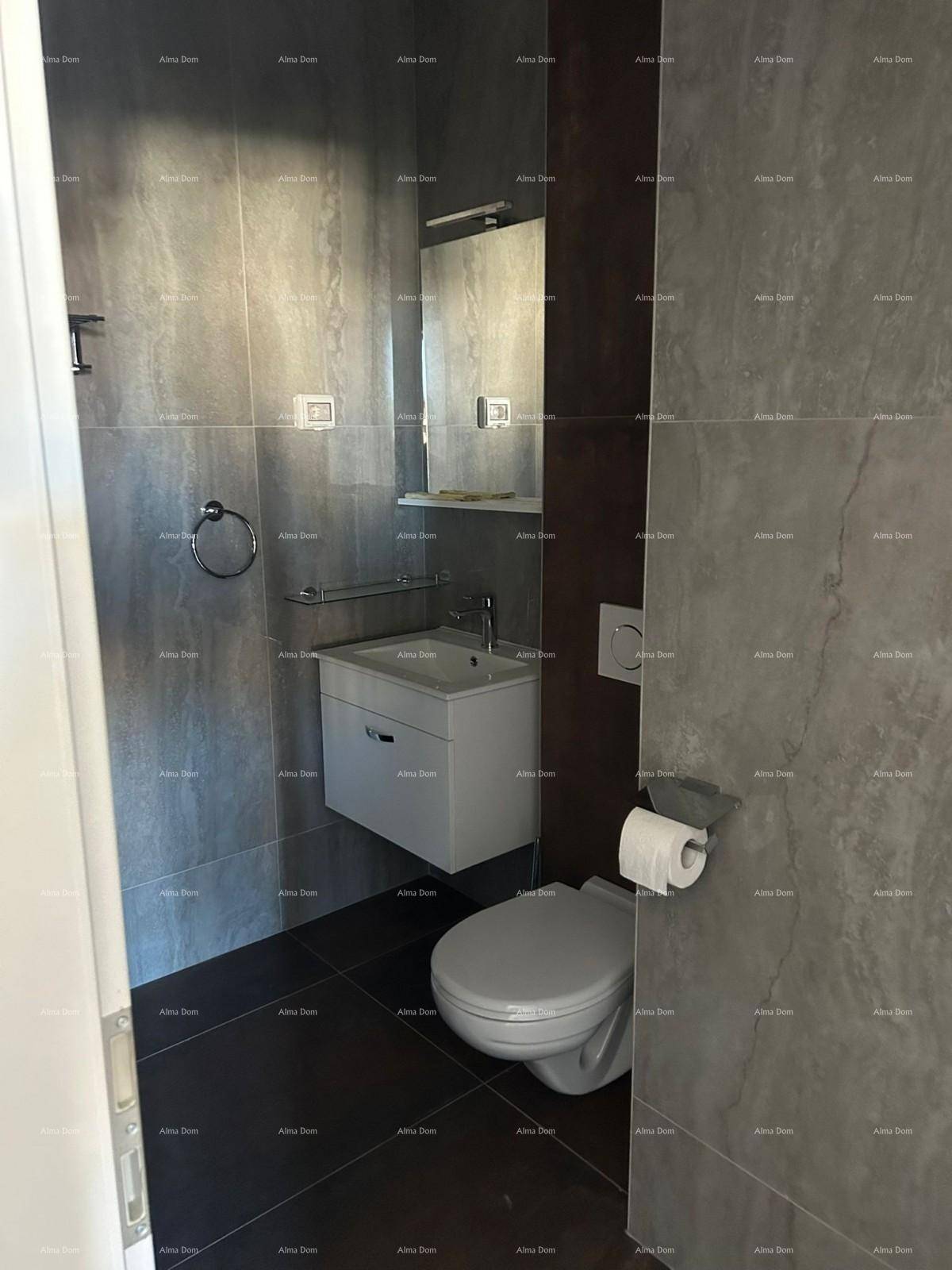 Kleines Badezimmer mit Wand-WC und modernem Waschtisch, komplett gefliest.