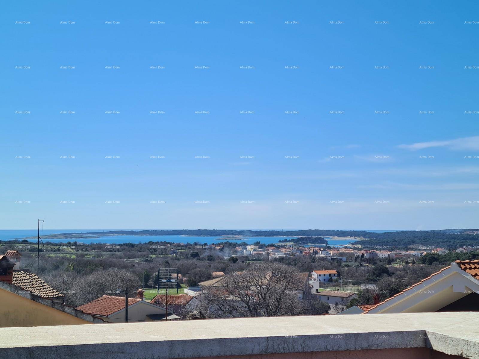 Panoramablick über die Küstenlandschaft mit Häusern und dem Meer in der Ferne.