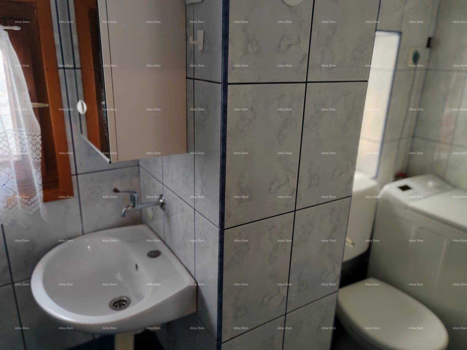 Badezimmer mit Waschbecken, Toilette, Waschmaschine und hellen Fliesen.