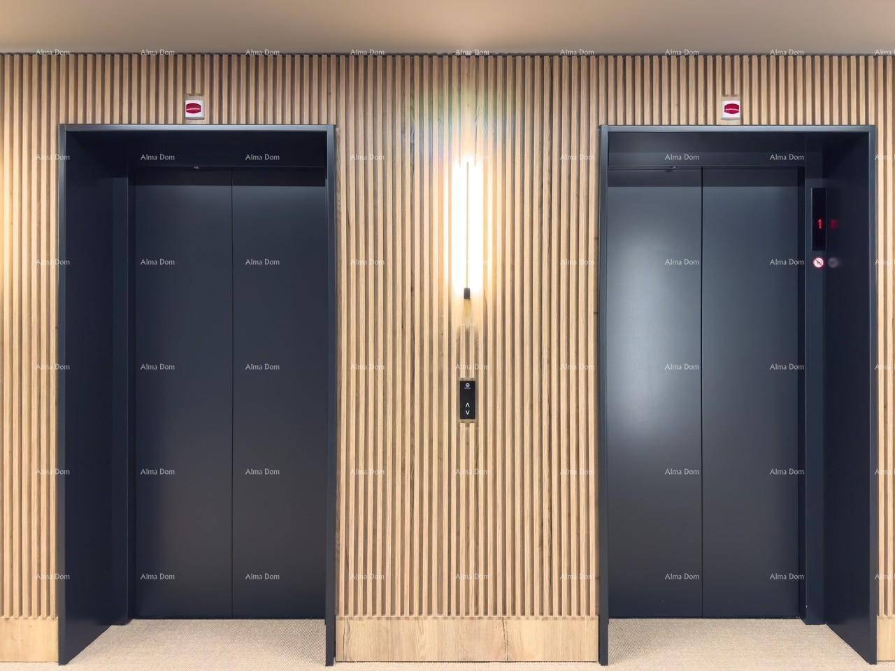 Zwei moderne Aufzüge in einem eleganten Flur mit vertikalen Holzlamellen und stilvoller Beleuchtung.