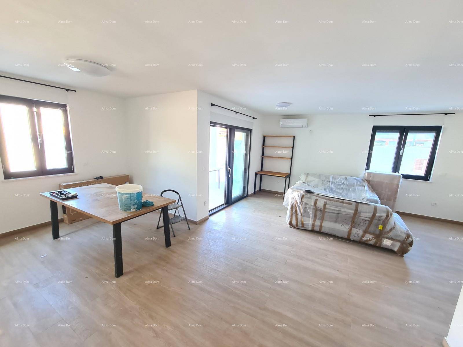 Heller Wohn- und Essbereich mit großem Holztisch, verpackten Möbeln und Zugang zum Balkon.