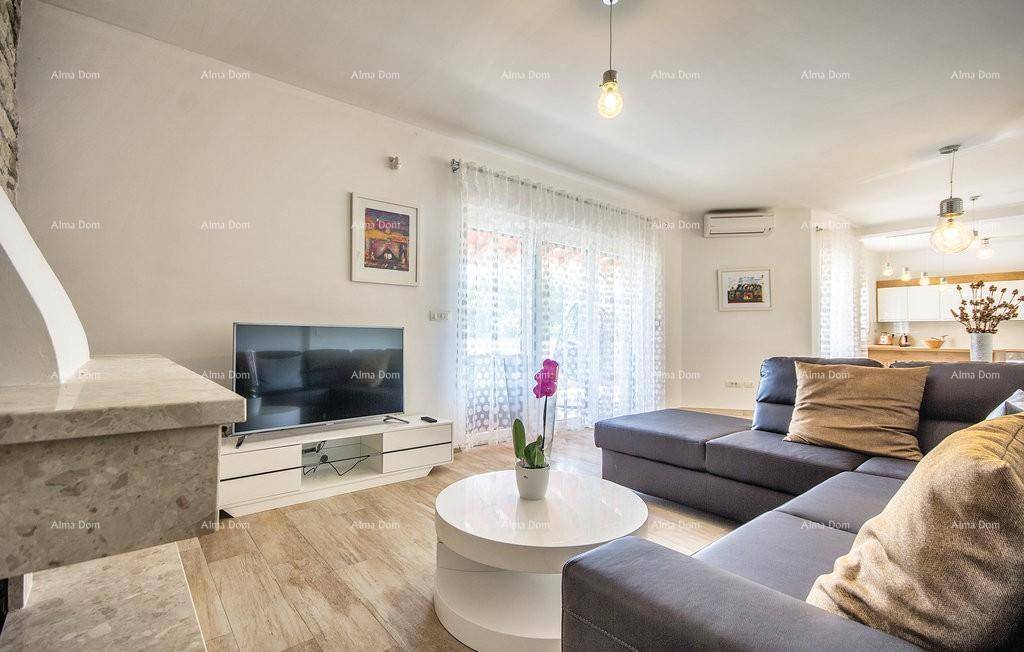 Gemütliches Wohnzimmer mit großem Sofa, Fernseher und hellem Fliesenboden.