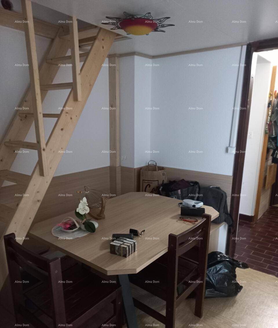 Essbereich mit Holztisch und Stühlen, ergänzt durch eine Holzleiter, die zu einem oberen Bereich führt.