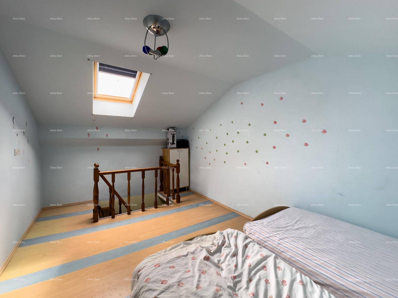 Geräumiges Dachgeschosszimmer mit Holzboden, Dachfenster und Zugang zur Treppe.