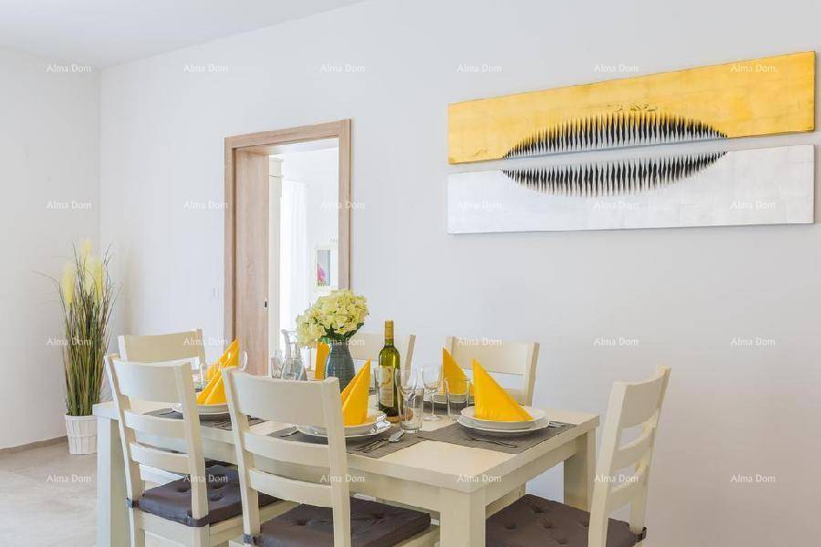 Heller Essbereich mit weißem Esstisch, Stühlen und moderner Wanddekoration in Gelb- und Grautönen.