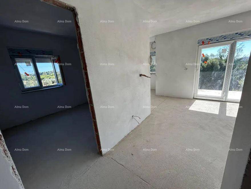 Unfertiger Innenraum mit Rohbauwänden und Blick durch eine große Schiebetür ins Freie.