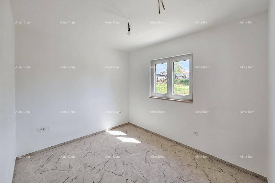 Leeres Schlafzimmer mit einem Fenster, das natürliches Licht hereinlässt, und gefliestem Boden.