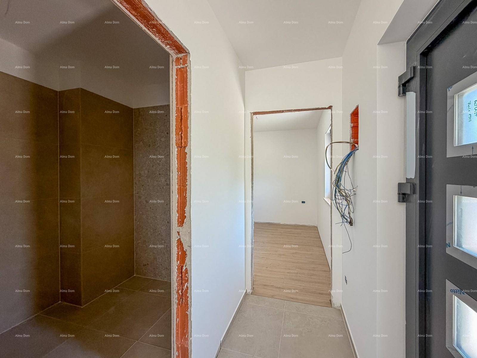 Eingangsbereich im Rohbau mit Fliesenboden, weißen Wänden und Blick in angrenzende Räume.