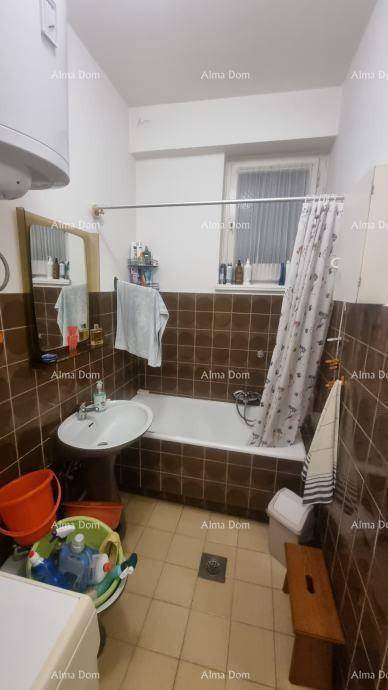 Badezimmer mit Badewanne, Waschbecken, Toilette und braunen Fliesen an Wänden und Boden.