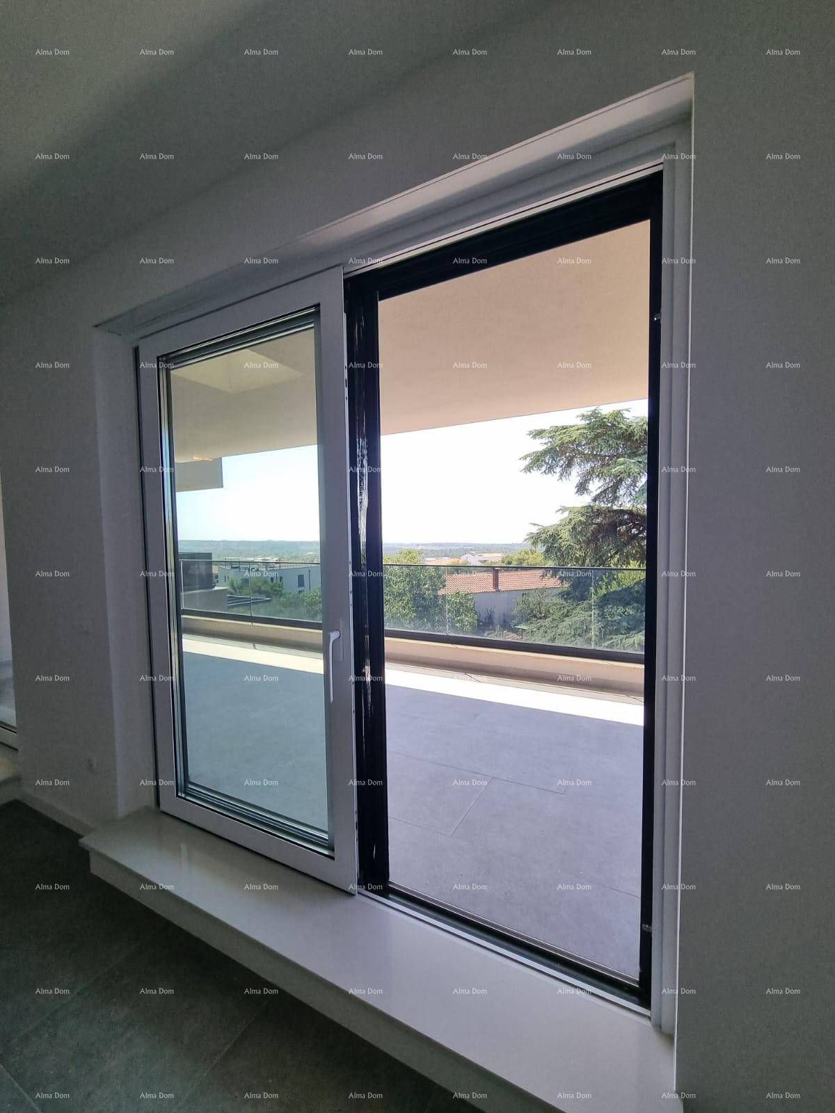 Große Glasschiebetür mit Zugang zu einem Balkon und weitem Blick in die grüne Umgebung.