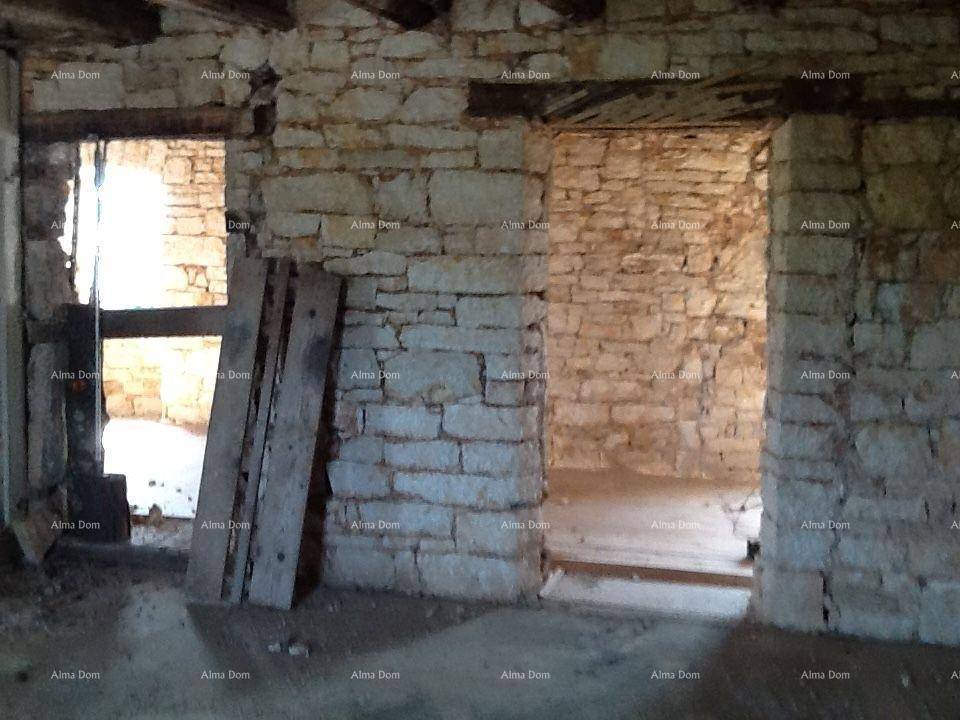 Rustikaler Innenraum mit freiliegenden Steinwänden und Holzbalken, bereit für die Renovierung.