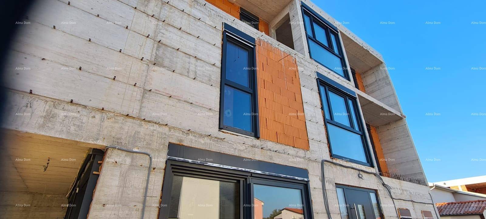 Fassade des Neubaus mit großen Fenstern und sichtbaren Dämmmaterialien im Bauzustand.