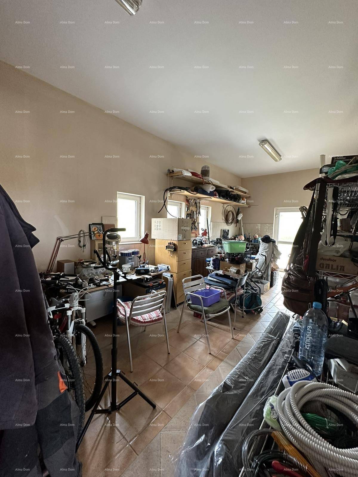 Geräumiger Arbeitsraum oder Werkstatt mit viel Stauraum und Tageslicht durch Fenster.