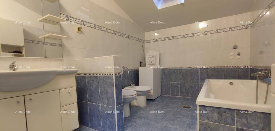 Geräumiges Badezimmer mit Badewanne, Bidet, Waschbecken und blauen Fliesen.