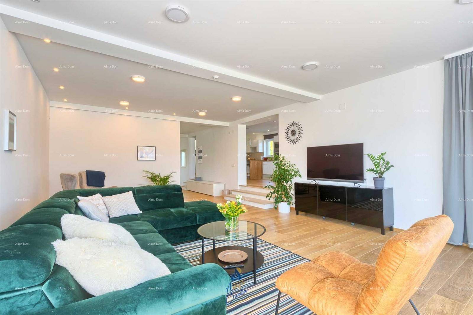 Helles Wohnzimmer mit moderner grüner Eckcouch, Holzboden und Blick auf den Essbereich.