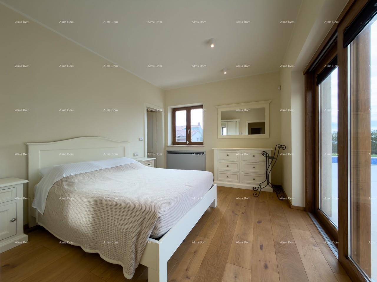 Geräumiges Schlafzimmer mit Doppelbett, Kommode und großen Glasschiebetüren zum Außenbereich.