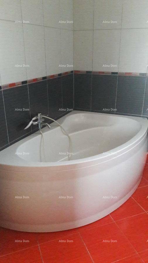 Badezimmer mit einer modernen Badewanne und kontrastierenden Wand- und Bodenfliesen.