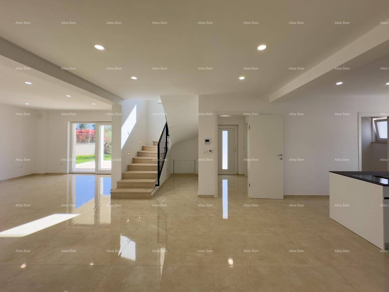 Geräumiger, offener Wohnbereich mit eleganter Treppe und Zugang zum Garten durch große Glastüren.