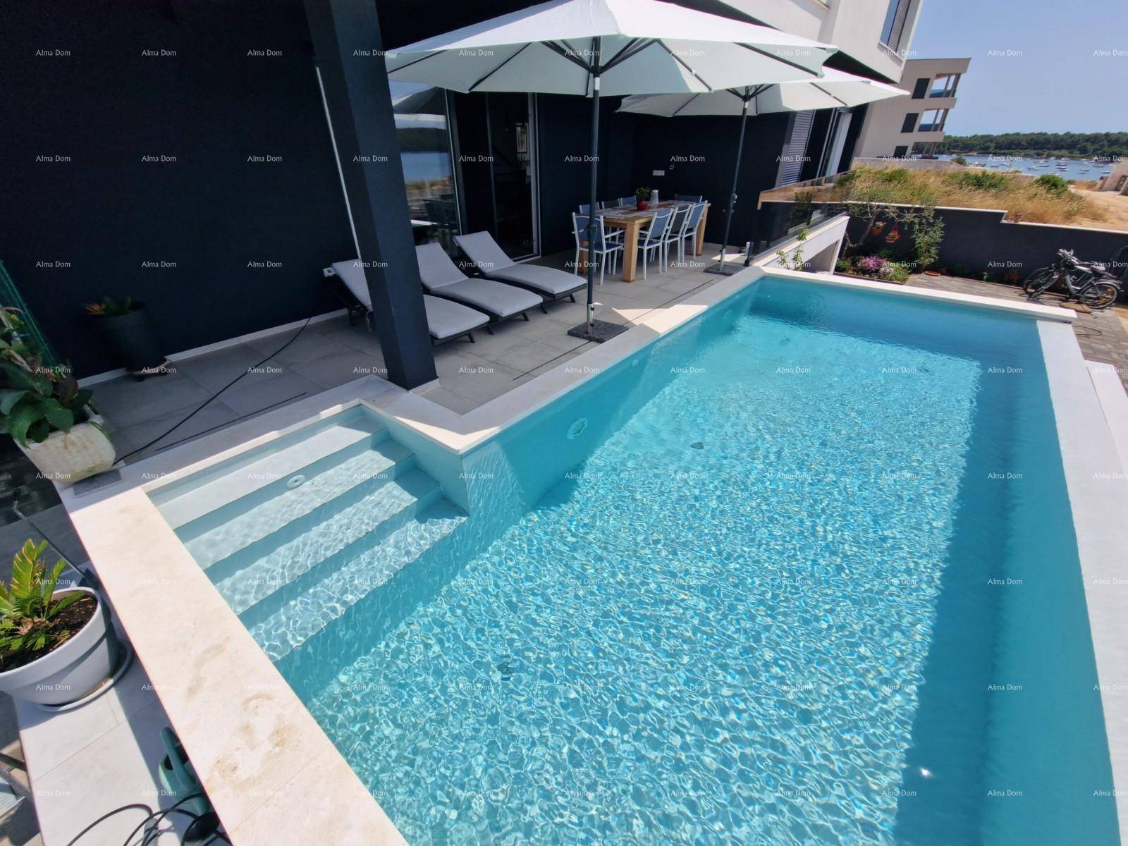 Klarer Swimmingpool mit integrierten Stufen, umgeben von einer modernen Terrassenfläche.