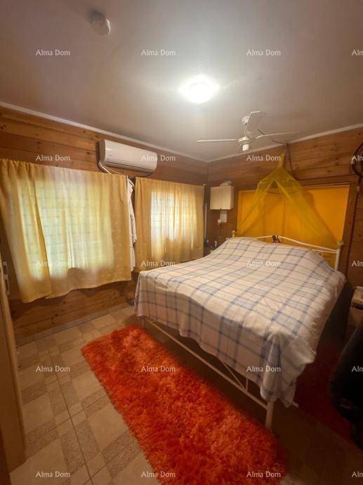 Rustikales Schlafzimmer mit Holzvertäfelung, Doppelbett und Klimaanlage.