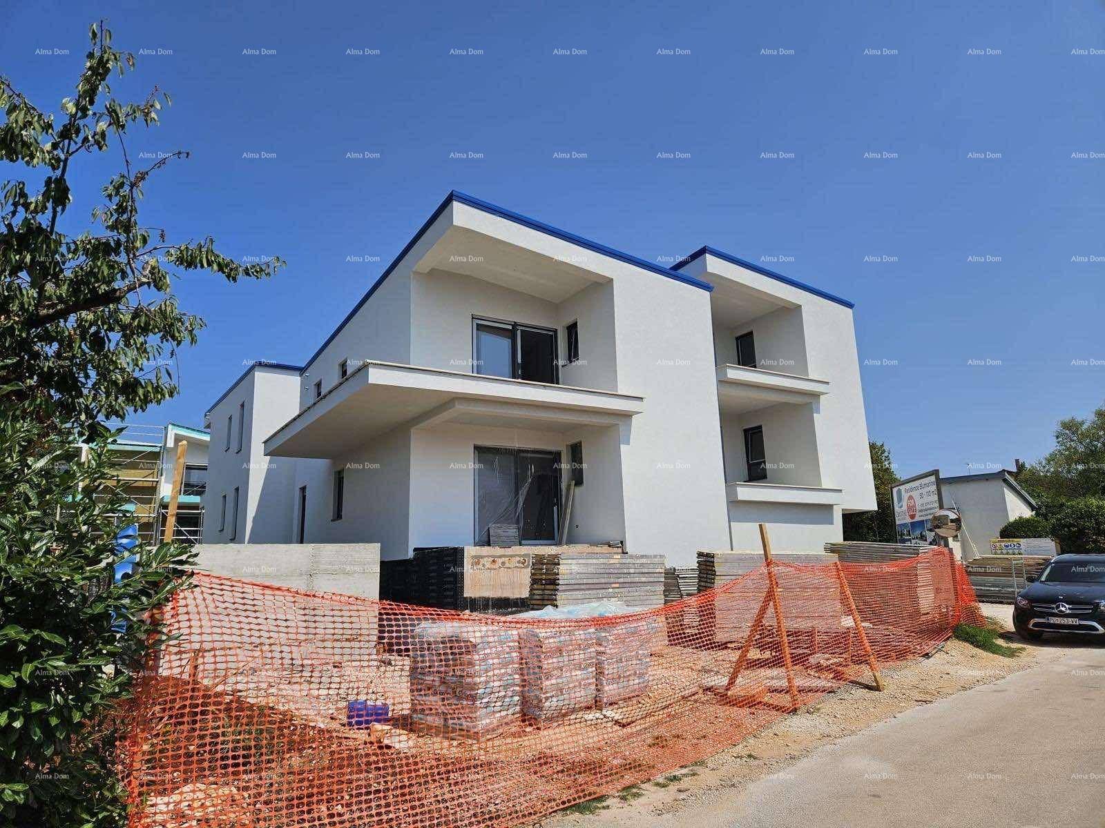 Neubau in moderner Architektur mit weißer Fassade und blauen Dächern, umgeben von Baustellenmaterialien.