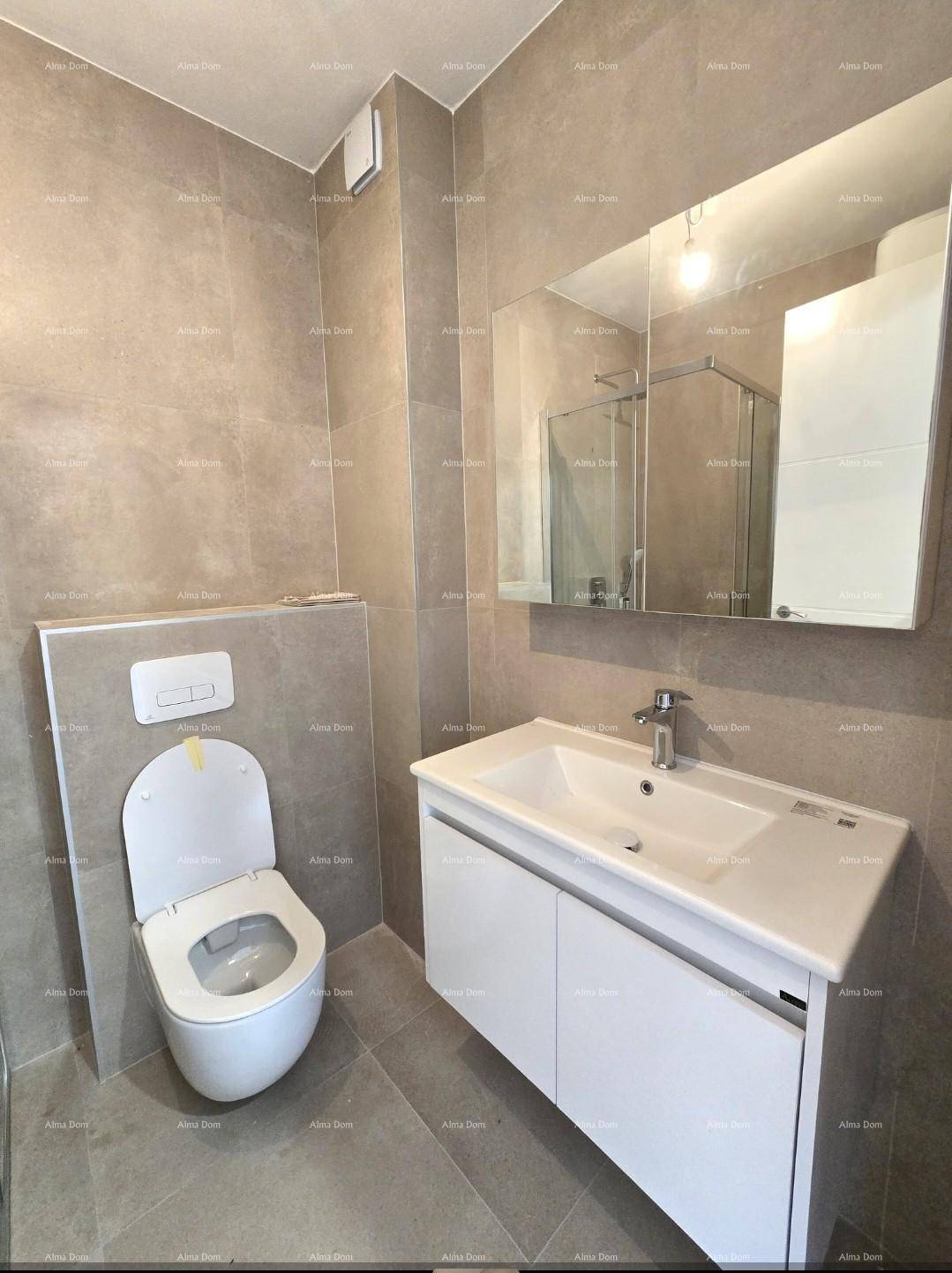 Modernes Badezimmer mit grauen Fliesen, wandhängendem WC und Waschtisch mit Spiegel.