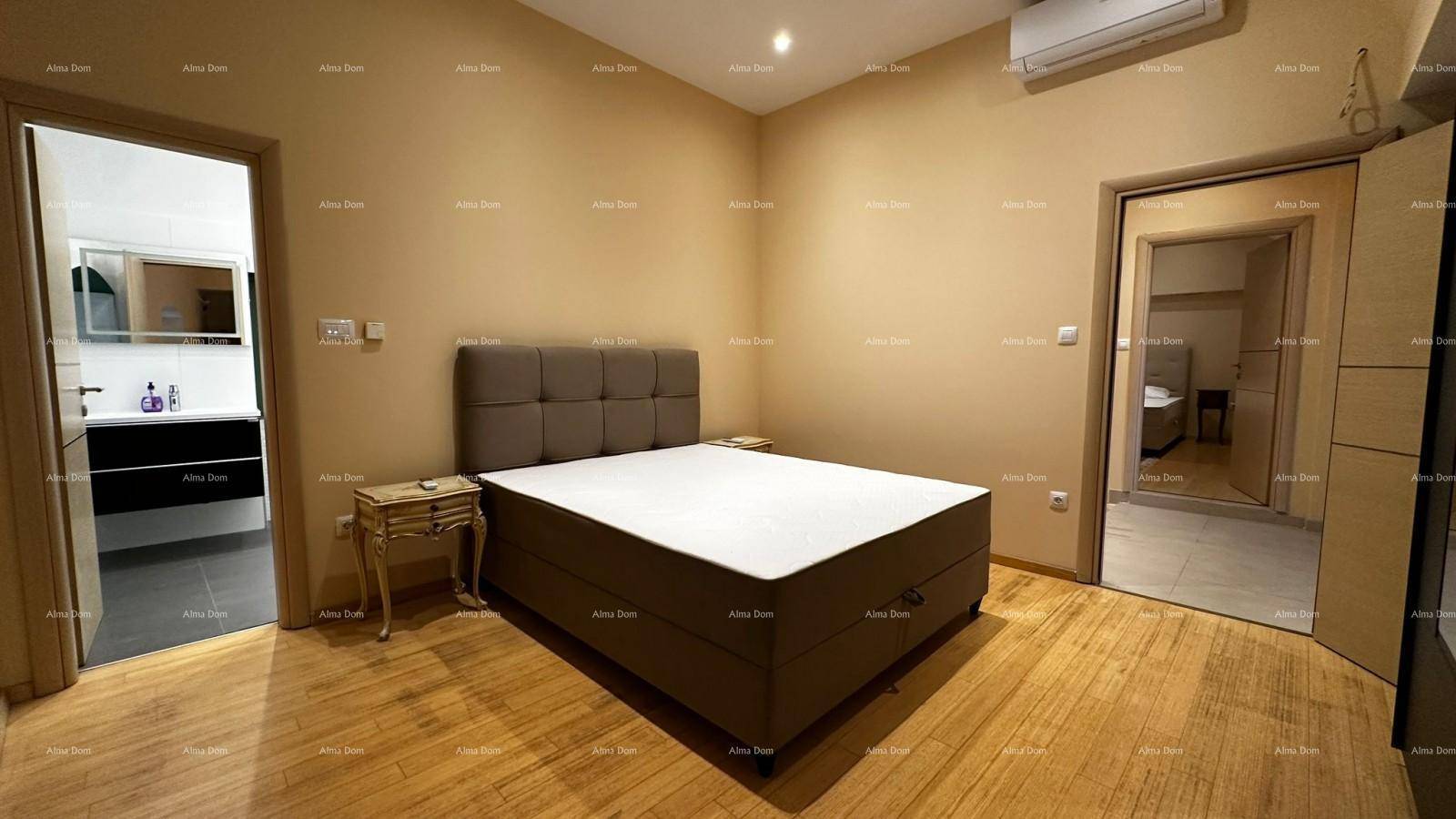 Schlafzimmer mit Doppelbett, Holzboden und direktem Zugang zu einem modernen Badezimmer.
