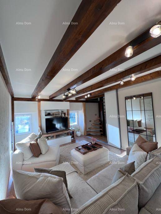 Modernes Wohnzimmer mit Fernseher, bequemen Sofas und Blick auf die elegante Wendeltreppe.