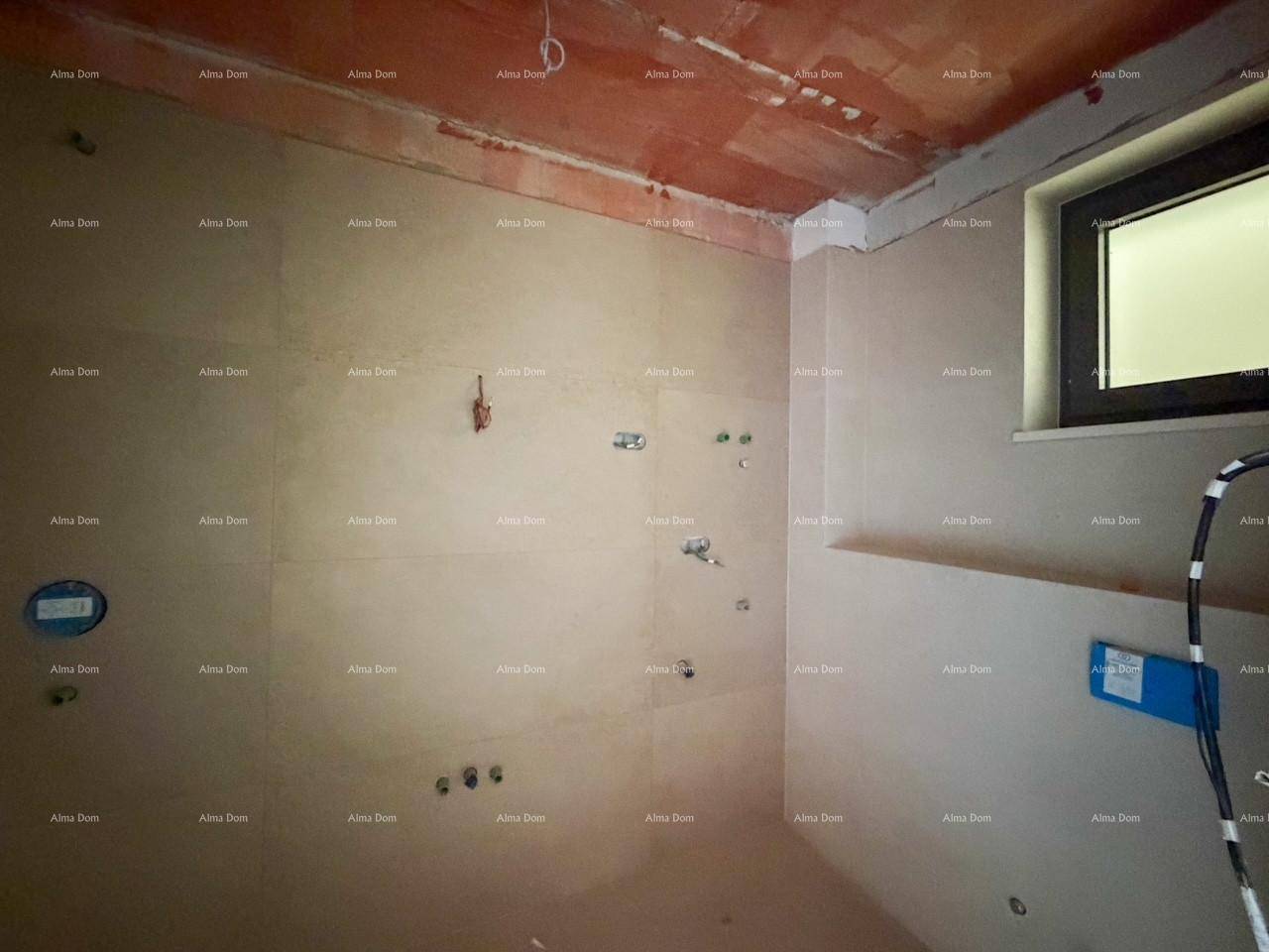 Badezimmer im Rohbau mit Fenster und vorbereiteten Anschlüssen für zukünftige Sanitärinstallationen.
