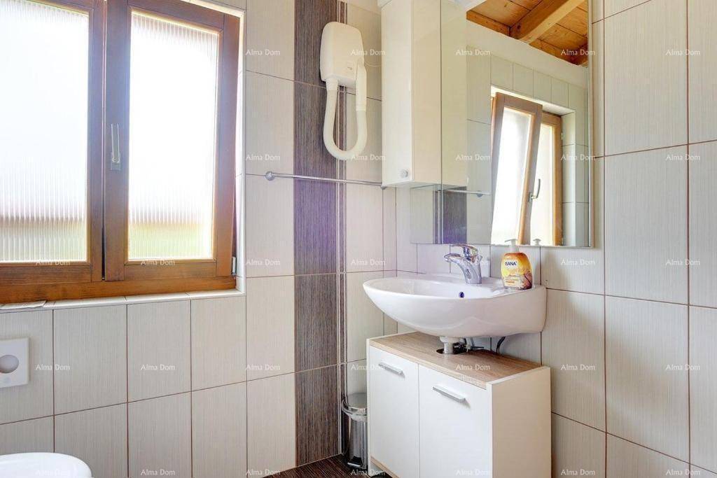 Modernes Badezimmer mit Waschbecken, Spiegelschrank und Fenster.