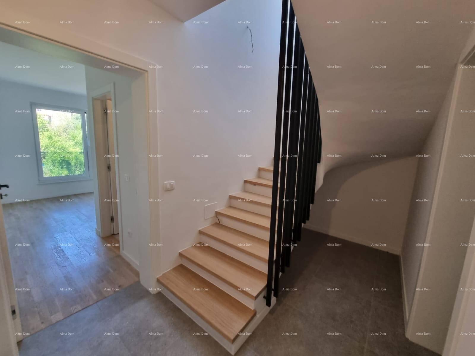 Heller Flur mit moderner Holztreppe und Fliesenboden, der zu weiteren Räumen führt.