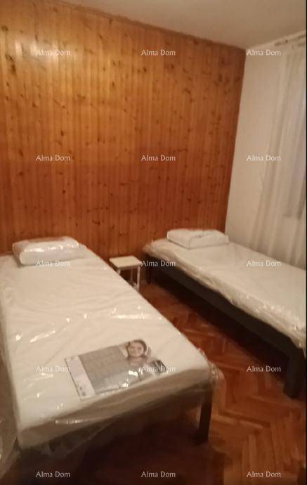 Schlafzimmer mit zwei Einzelbetten, Parkettboden und rustikaler Holzwandverkleidung.