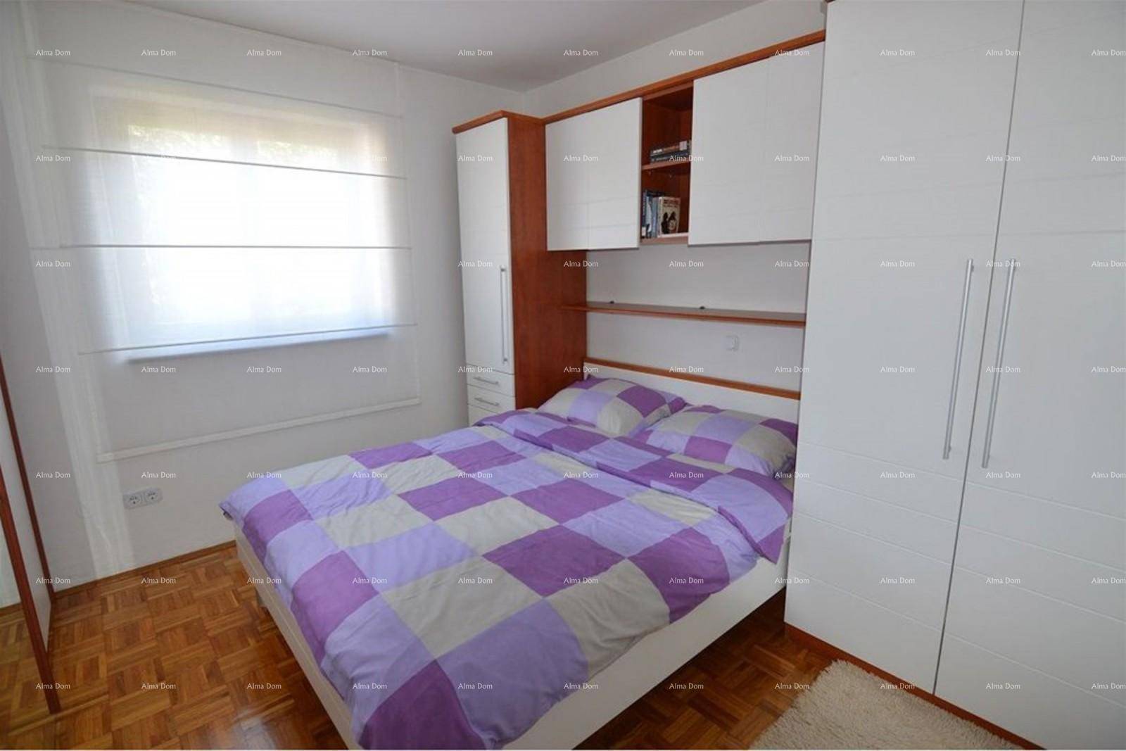 Helles Schlafzimmer mit Parkettboden, Doppelbett und Fenster.
