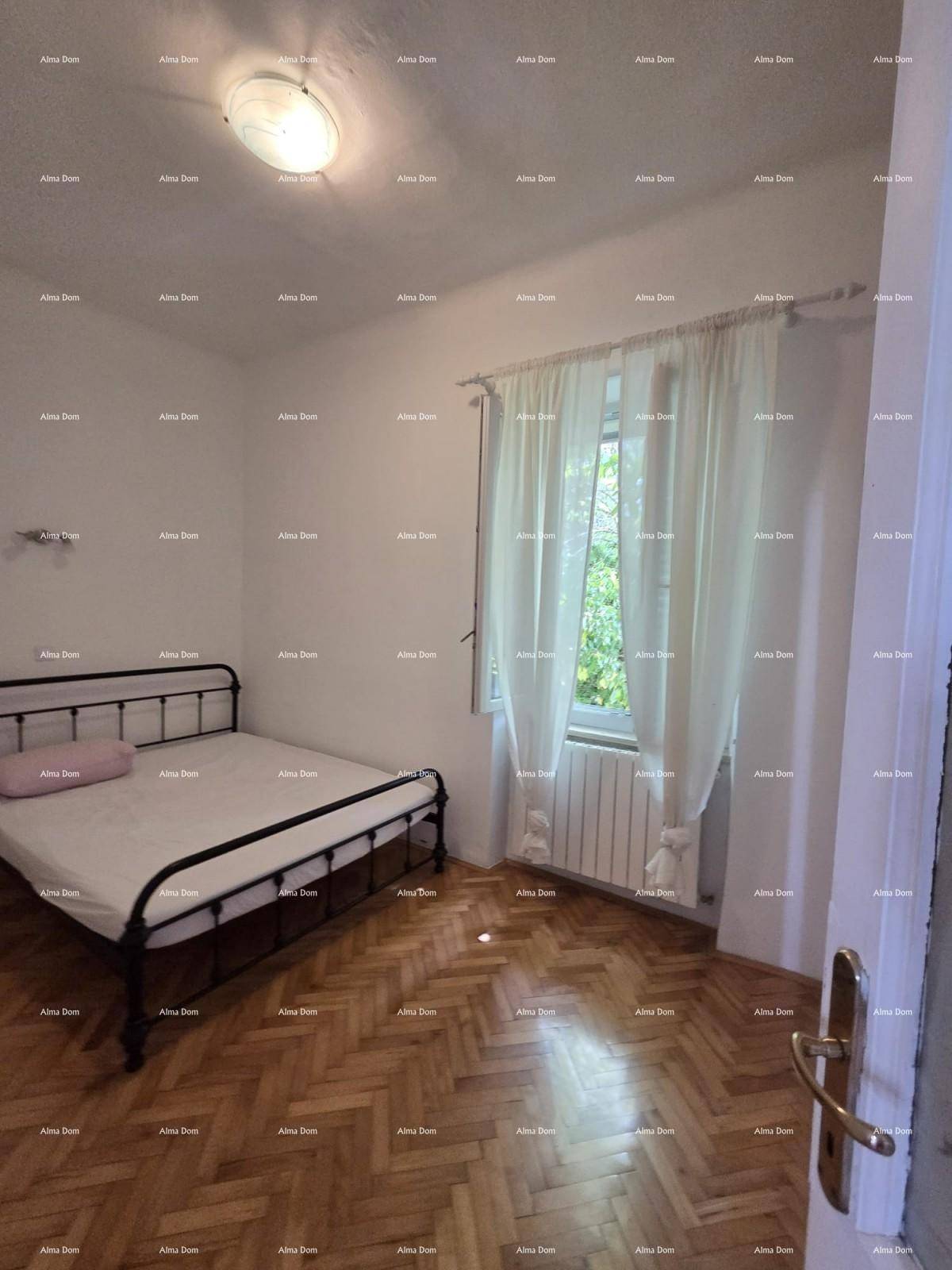 Ruhiges Schlafzimmer mit Metallbett, Parkettboden und Vorhängen am Fenster für Privatsphäre.