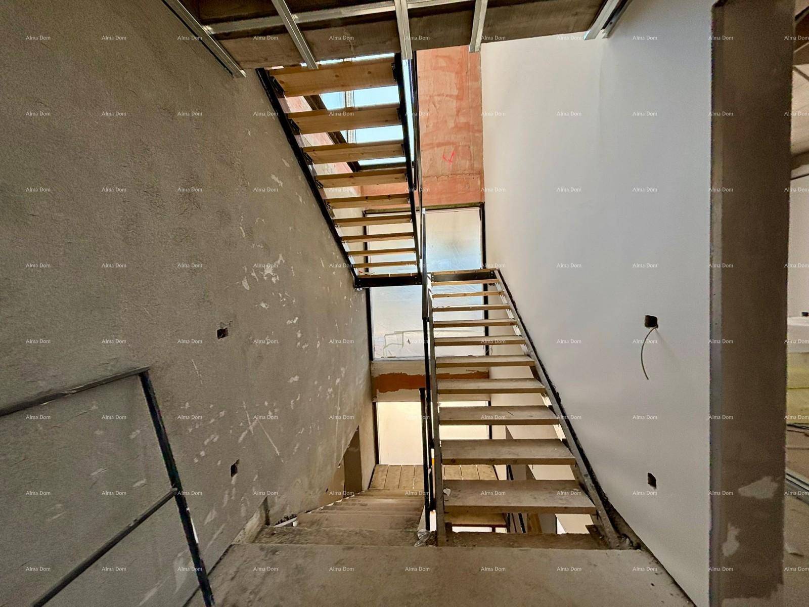 Treppenhaus im Rohbau mit Holzstufen und Metallgeländer, bereit für den weiteren Ausbau.
