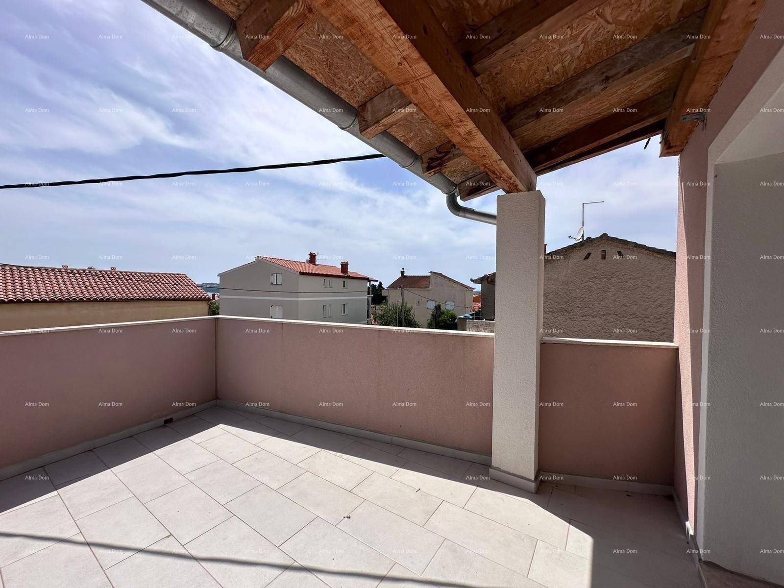 Geräumiger Balkon mit Fliesenboden und Blick auf die umliegenden Häuser und den blauen Himmel.
