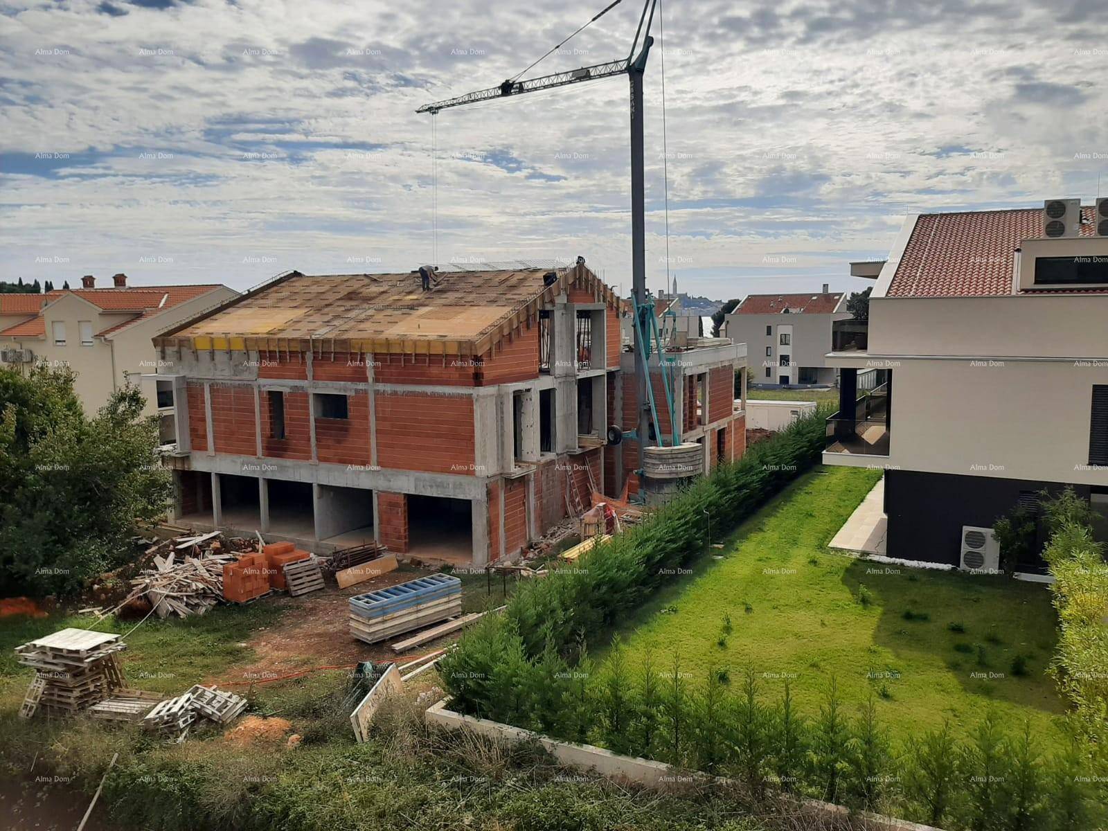 Baustelle eines im Bau befindlichen Hauses mit Ziegelwänden und Kran, mit Meerblick.