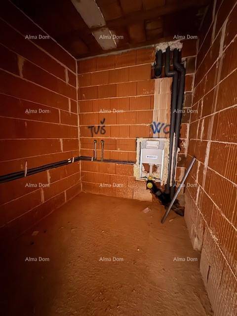 Rohbau-Badezimmer mit sichtbaren Installationen für Sanitäranlagen und Ziegelwänden.
