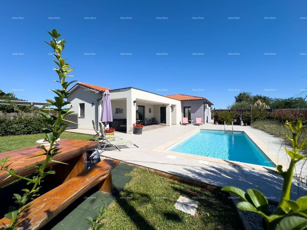 Weitläufiger Gartenbereich mit Pool, Holzbank und Blick auf die moderne Villa.