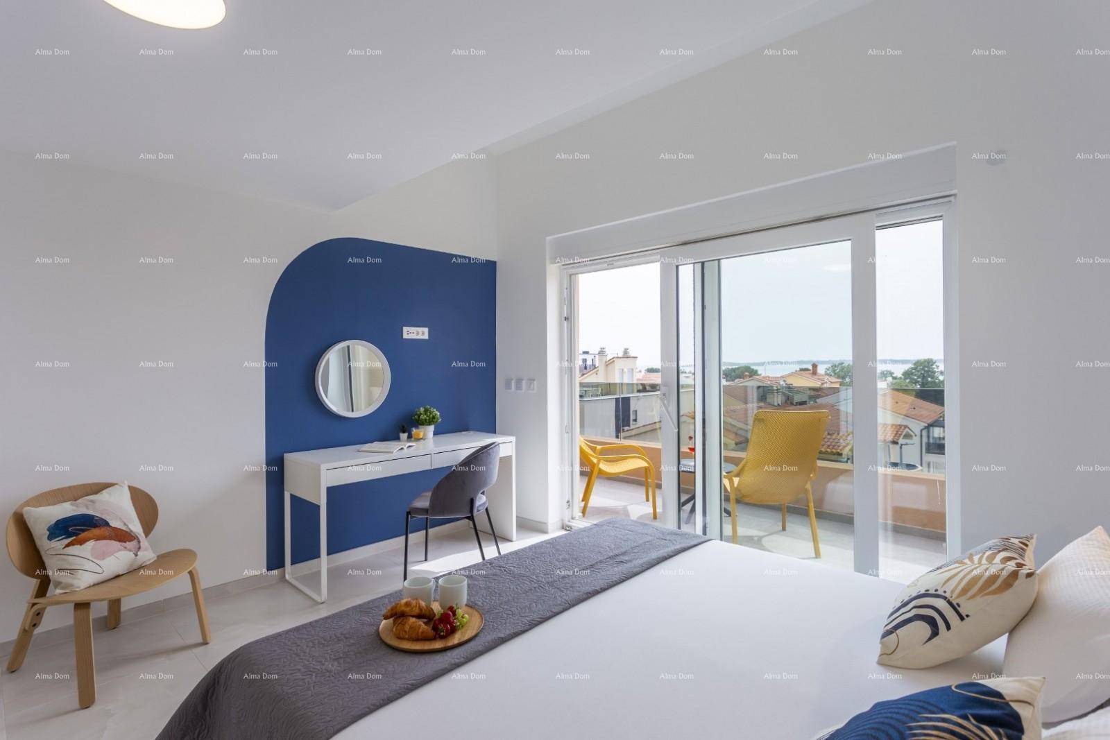 Modernes Schlafzimmer mit blauem Akzent, Schreibtisch und Balkonzugang mit Meerblick.