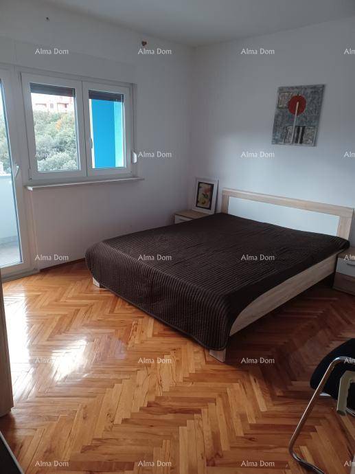Helles Schlafzimmer mit modernem Bett, Fischgrät-Parkettboden und großem Fenster für viel Tageslicht.