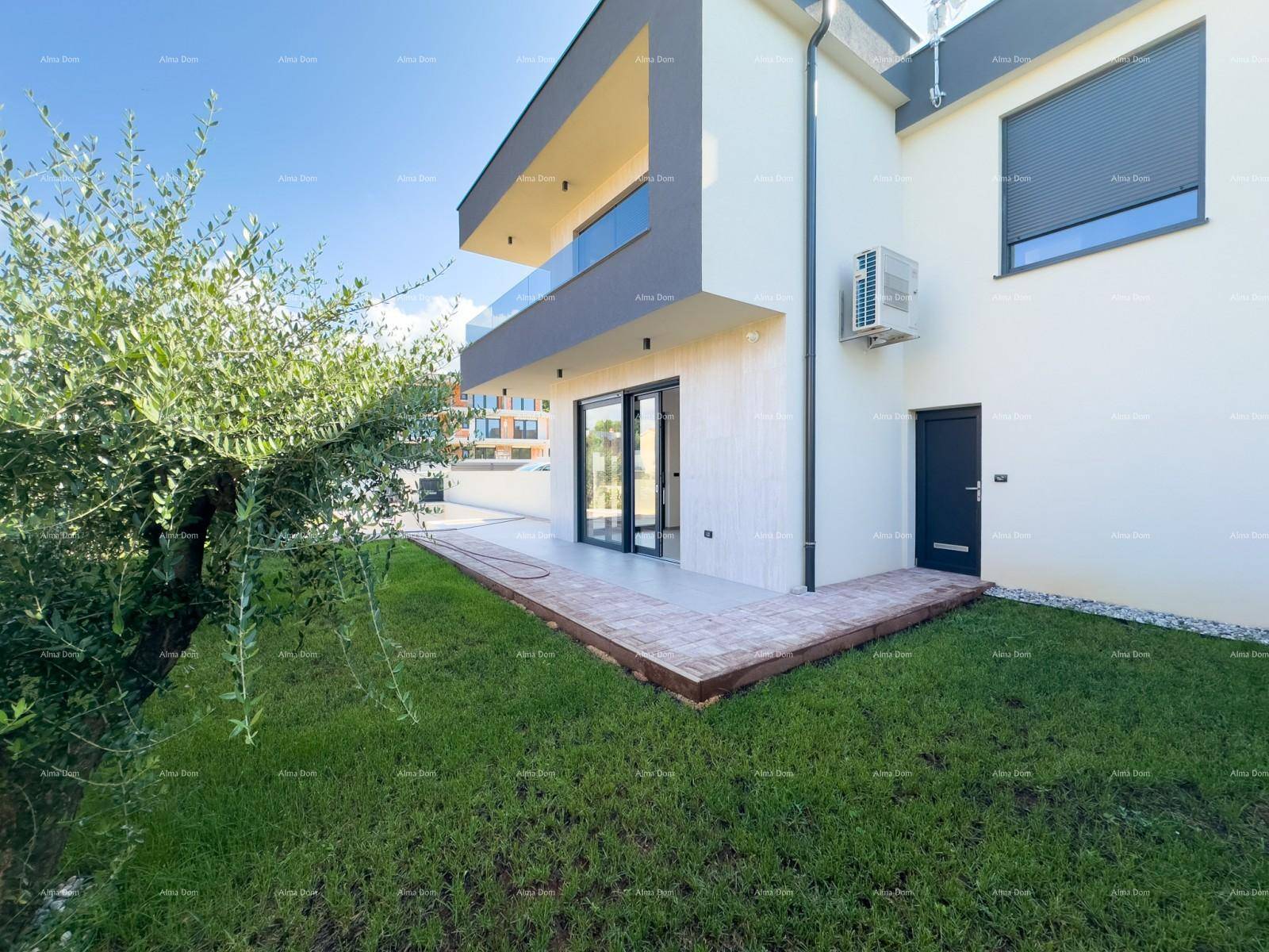 Seitenansicht der modernen Villa mit kleiner Terrasse und grünem Rasenbereich.