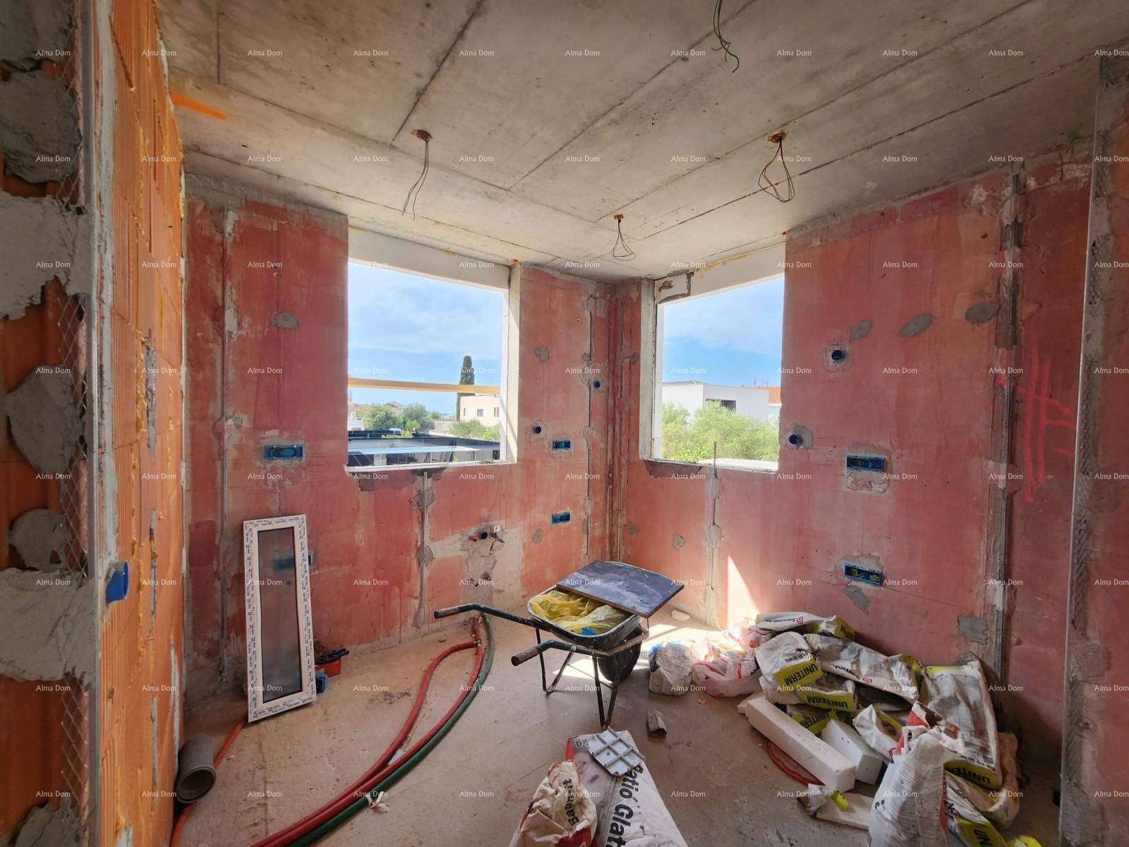Innenraum im Rohbau mit unverputzten Wänden, Betonboden und Blick nach draußen durch die Fenster.
