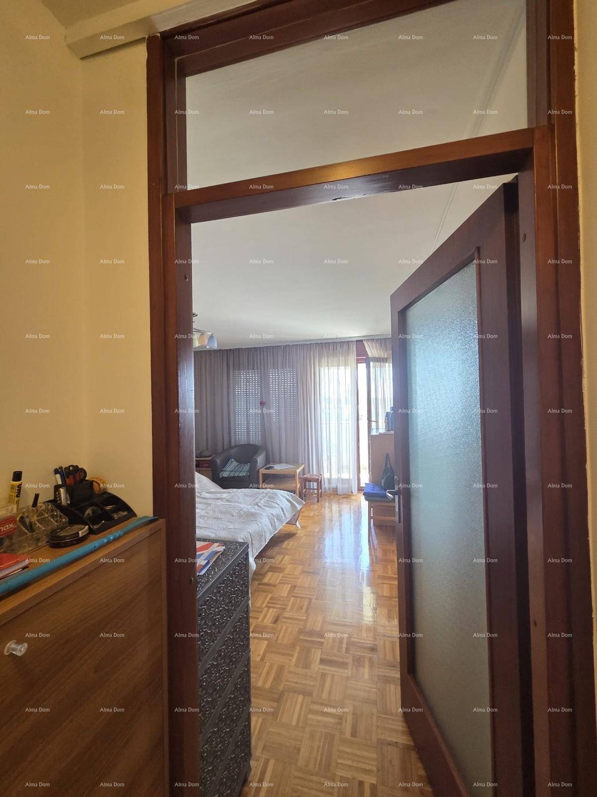 Blick vom Flur in das helle Wohnzimmer mit Parkettboden und Zugang zum Außenbereich.
