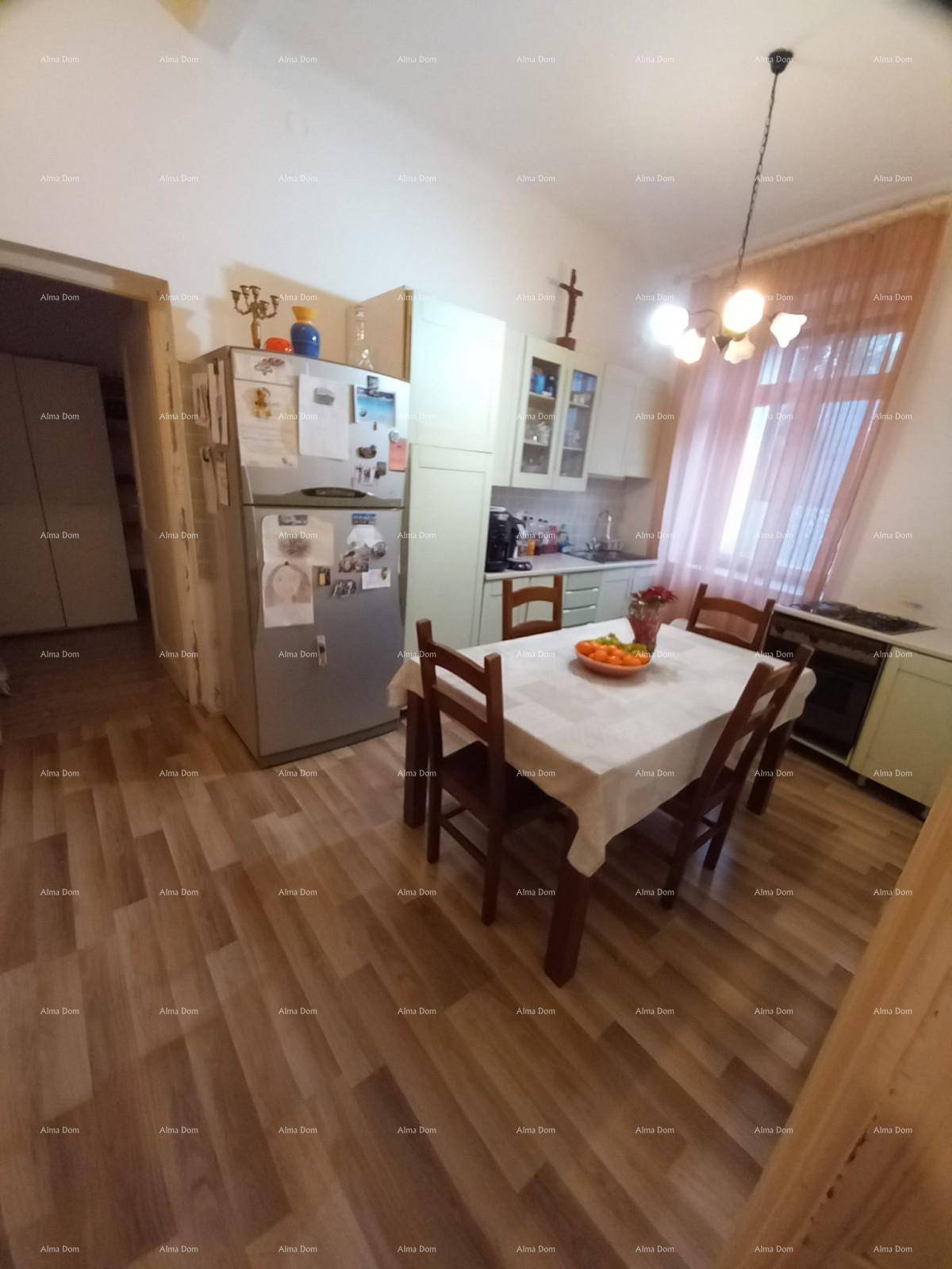Wohnküche mit Esstisch, Kühlschrank und hellgrünen Küchenschränken, ausgestattet für den Alltag.