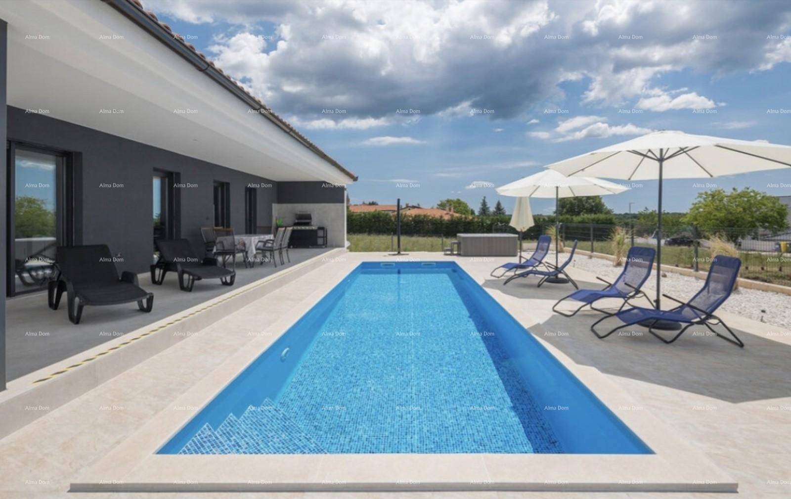 Langer, rechteckiger Pool mit blauen Mosaikfliesen und Liegestühlen auf der Sonnenterrasse.