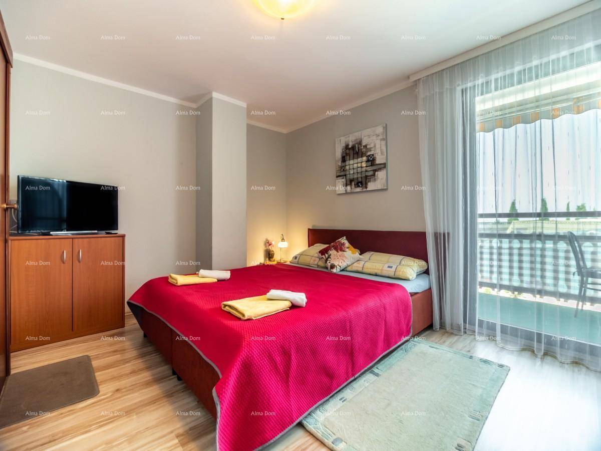 Helles Schlafzimmer mit Doppelbett, Fernseher, Klimaanlage und direktem Balkonzugang.