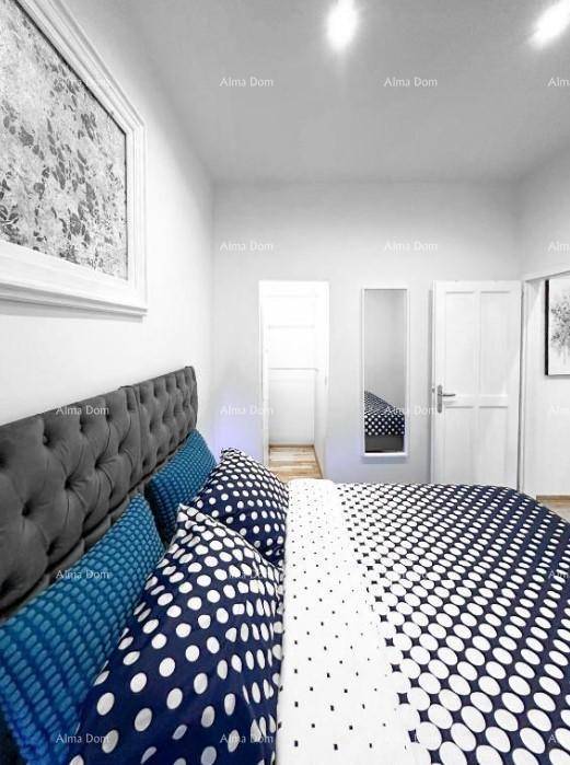 Modernes Schlafzimmer mit gepolstertem Kopfteil und auffälliger Bettwäsche in Blau-Weiß.